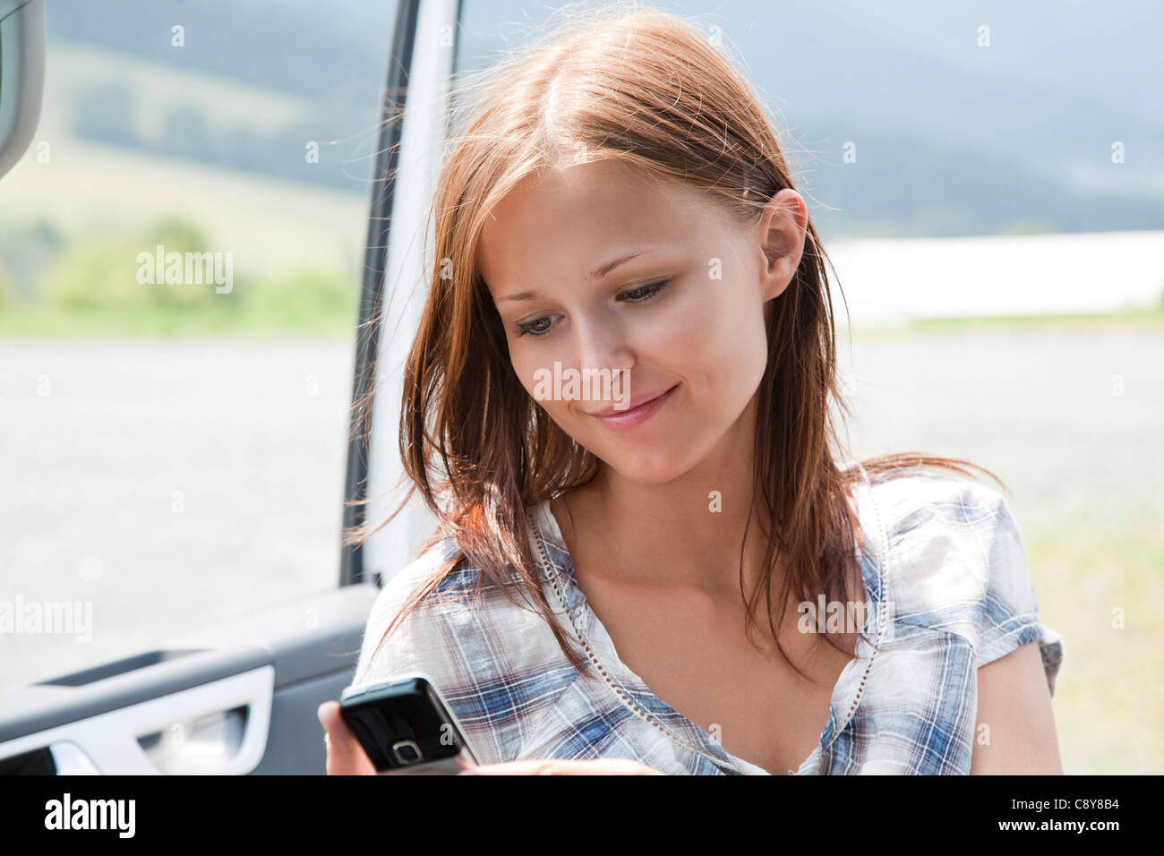 Portrait de jeune femme resding test message on mobile phone Banque D'Images