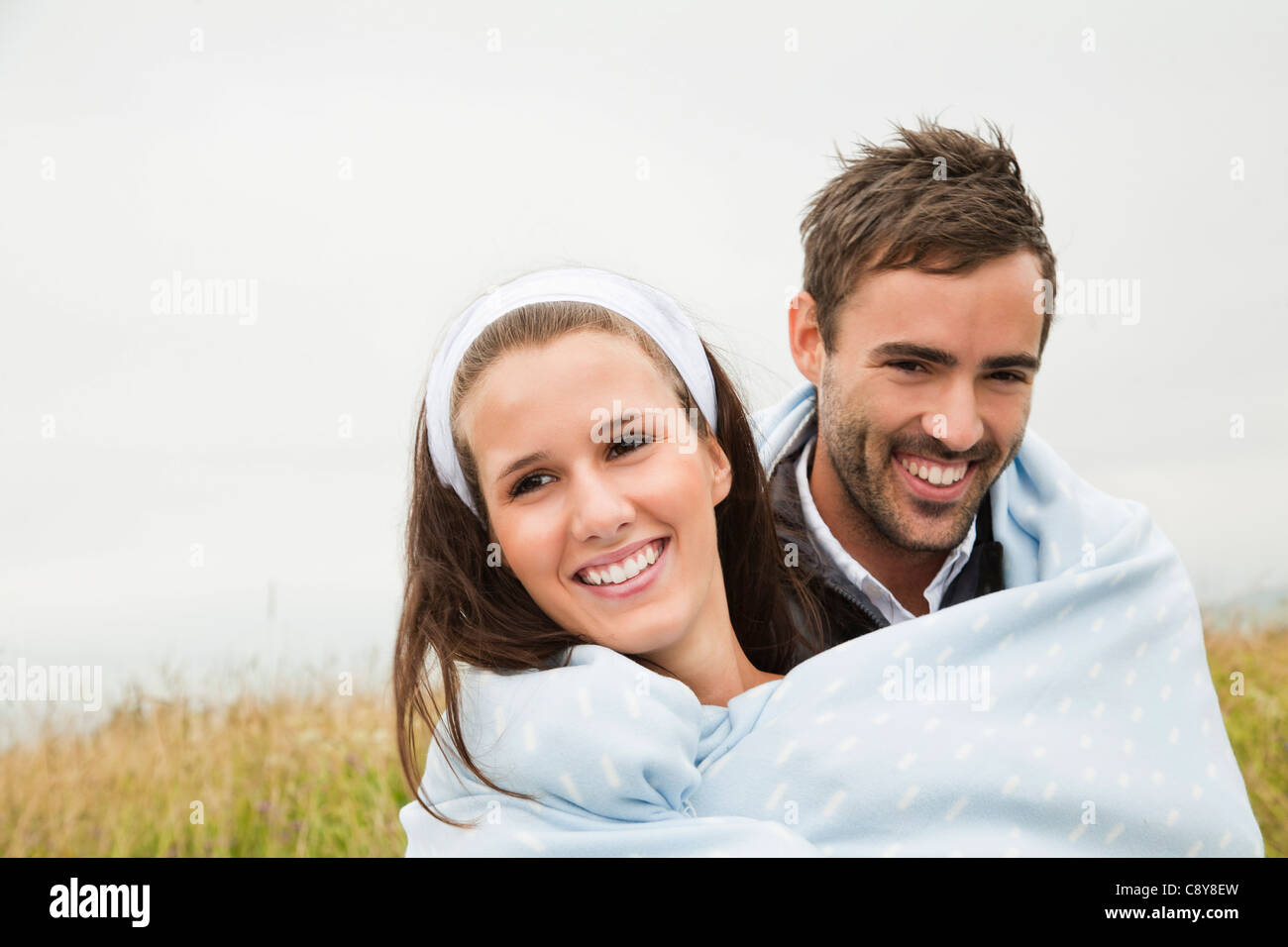 Portrait of young couple outdoors enveloppé dans une couverture Banque D'Images