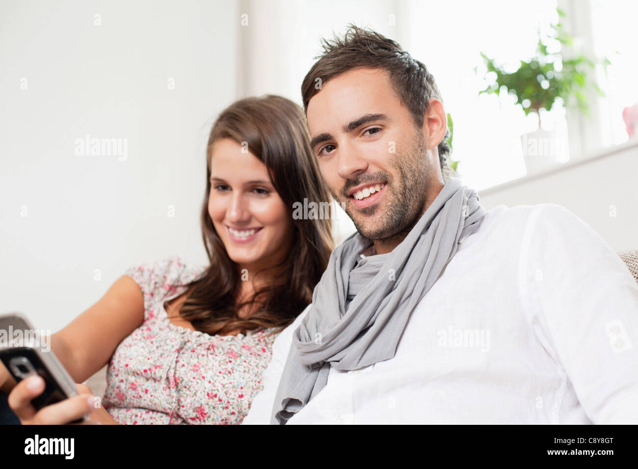 Portrait of young couple text message on mobile phone Banque D'Images