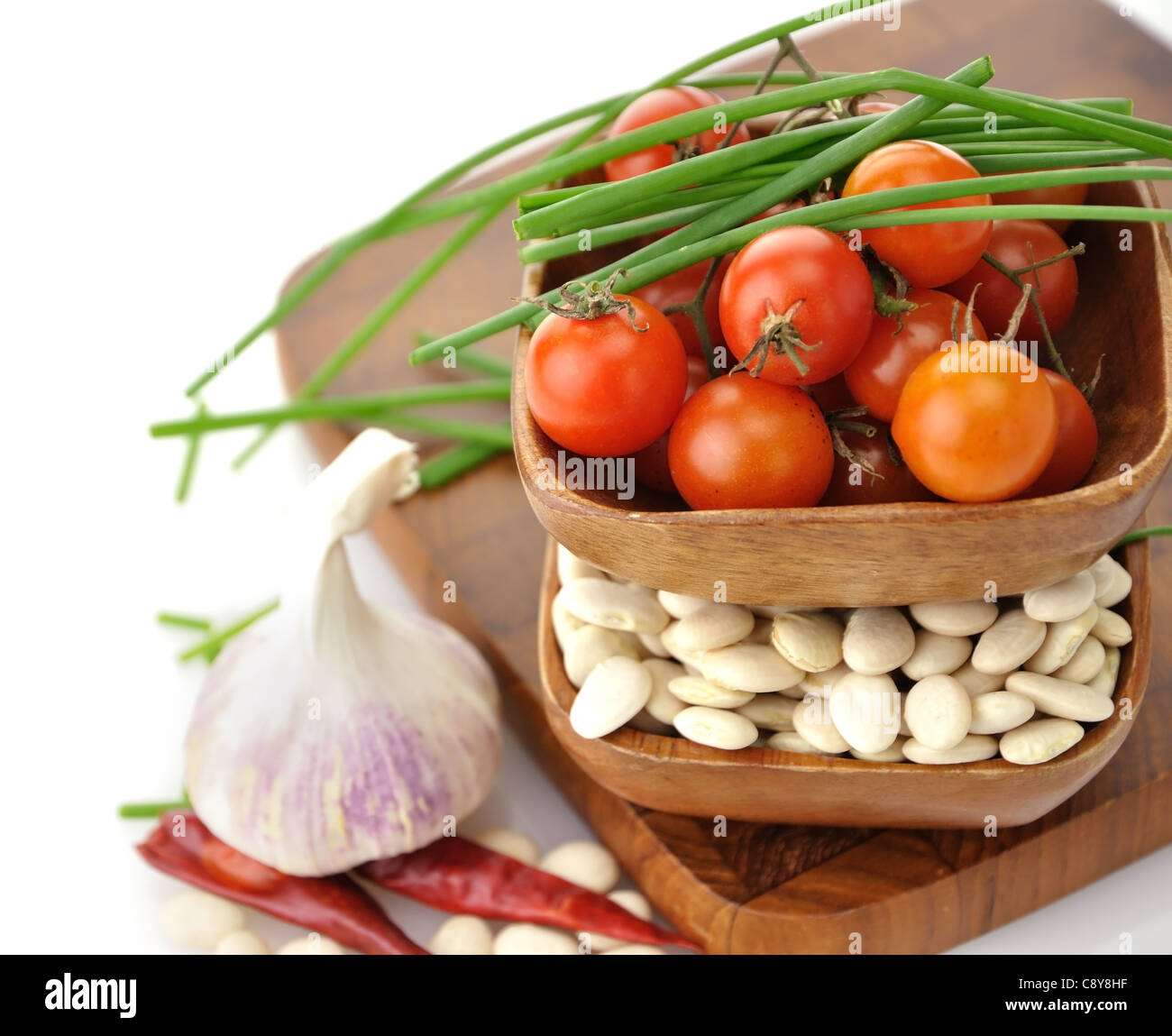 Les haricots de Lima de bébé , les tomates et les épices dans des bols en bois Banque D'Images