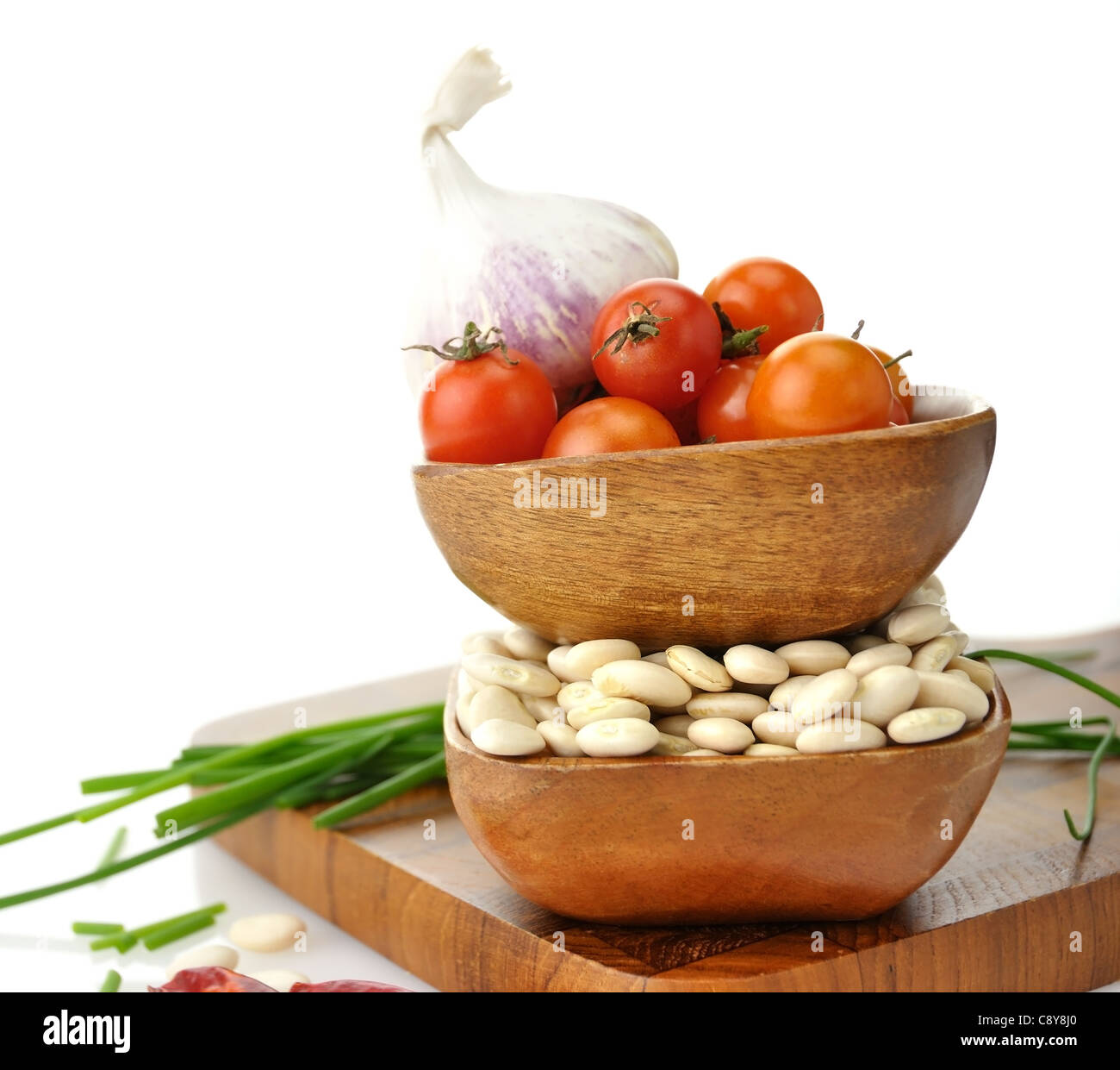 Les haricots de Lima de bébé , les tomates et les épices dans des bols en bois Banque D'Images