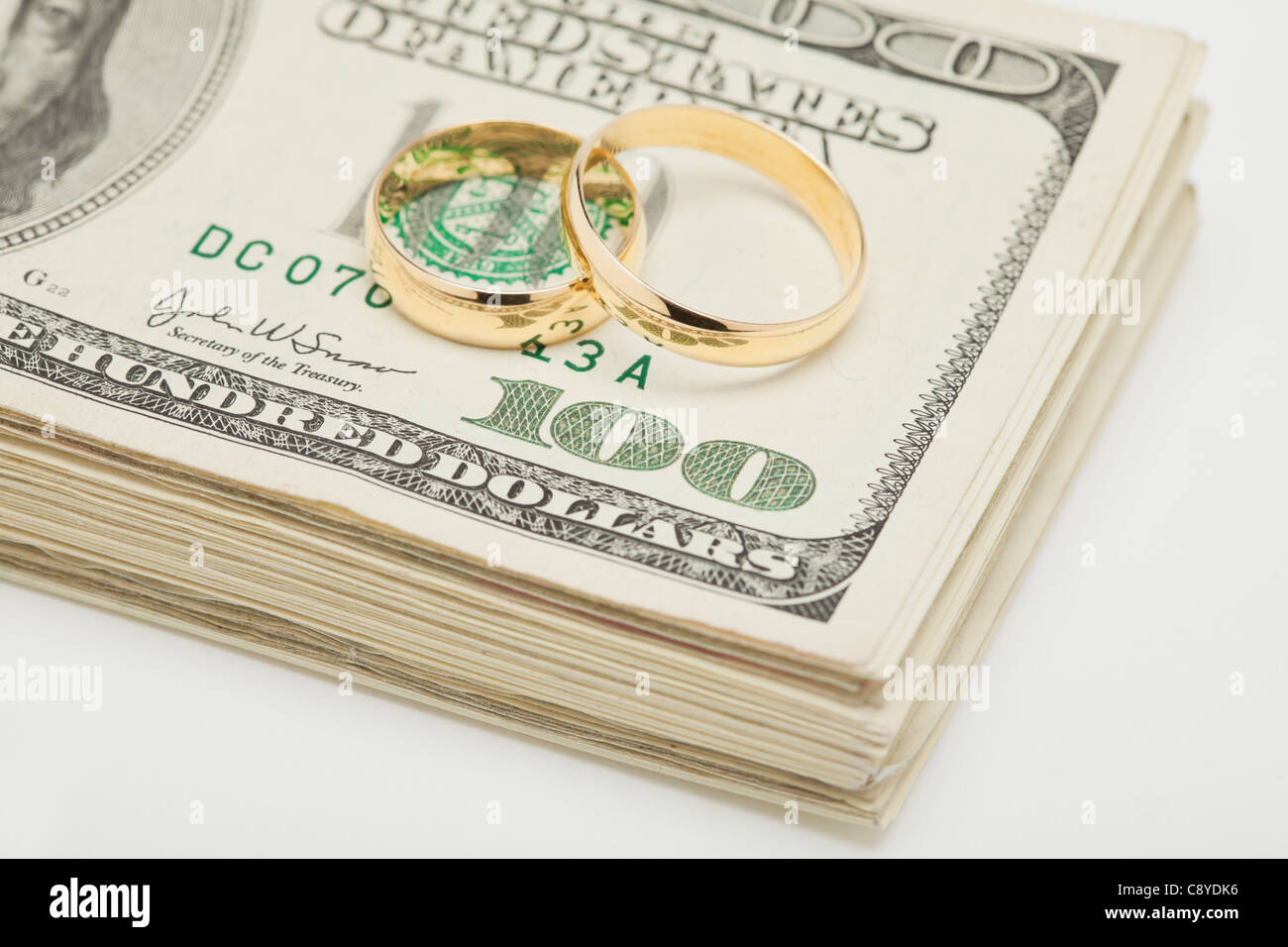 Anneau de mariage fils tas de billets en dollars, studio shot Banque D'Images