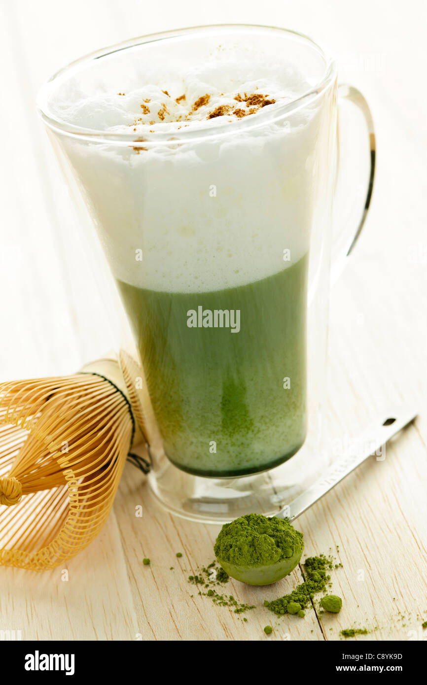 Thé vert matcha latte mug en verre de boissons avec un fouet Banque D'Images