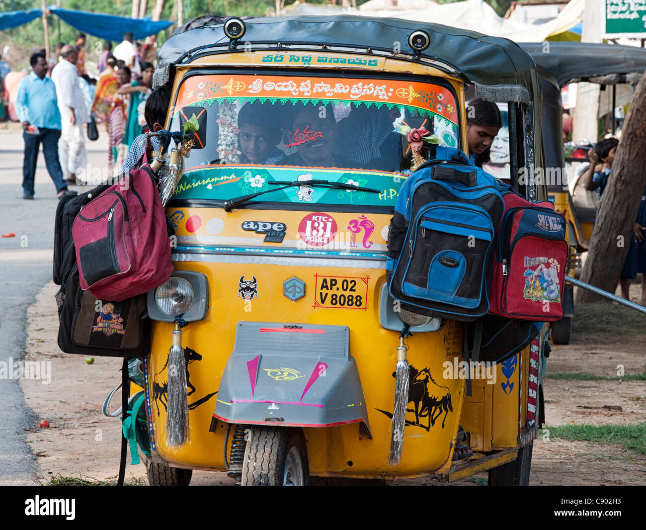 Auto rickshaw indien plein d'enfants de l'école avec leur sac accroché à l'aile . L'Andhra Pradesh, Inde Banque D'Images