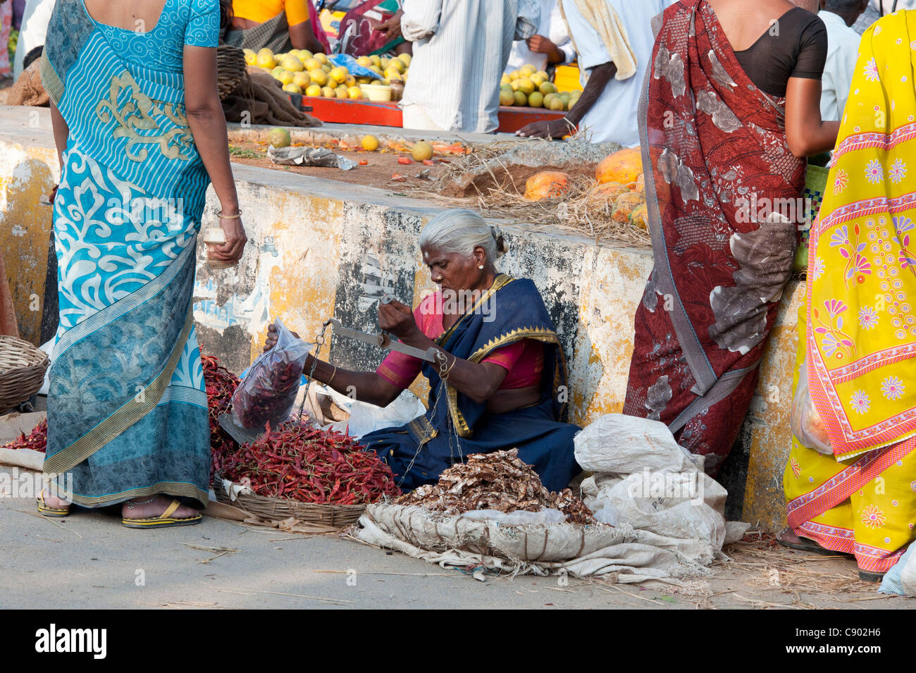 Femme vendant de l'Inde rurale du piment rouge à un Indien de la rue du marché à Puttaparthi Banque D'Images