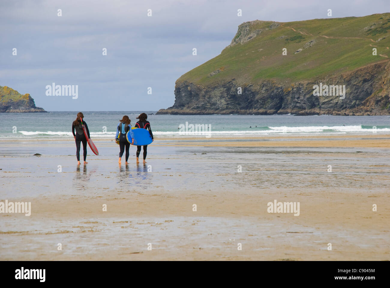 Les surfeurs sur la plage de Polzeath, Cornwall, UK Banque D'Images