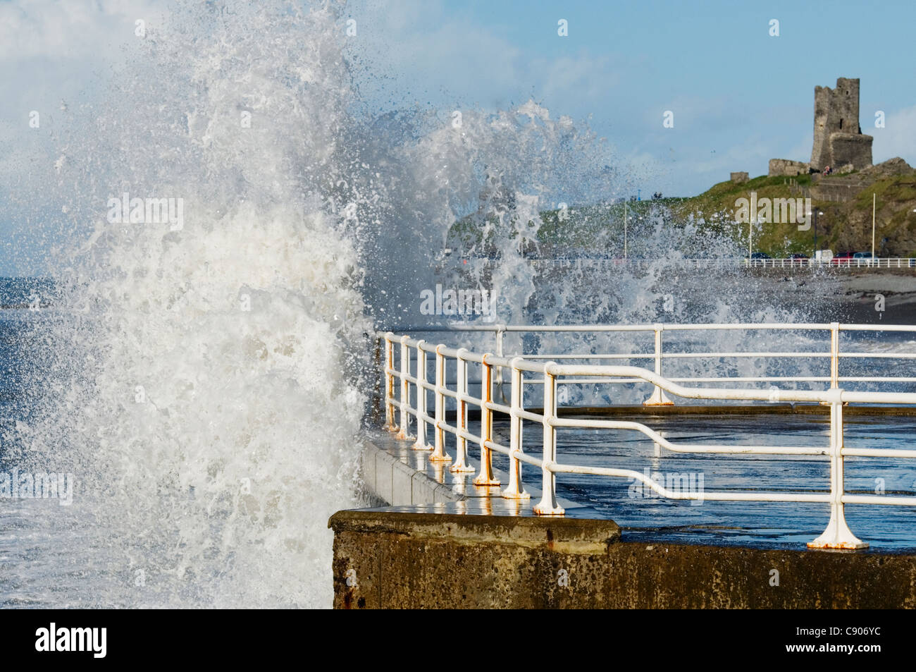 Une journée ensoleillée à Aberystwyth hivers avec les vagues s'écraser sur les murs du port. Banque D'Images