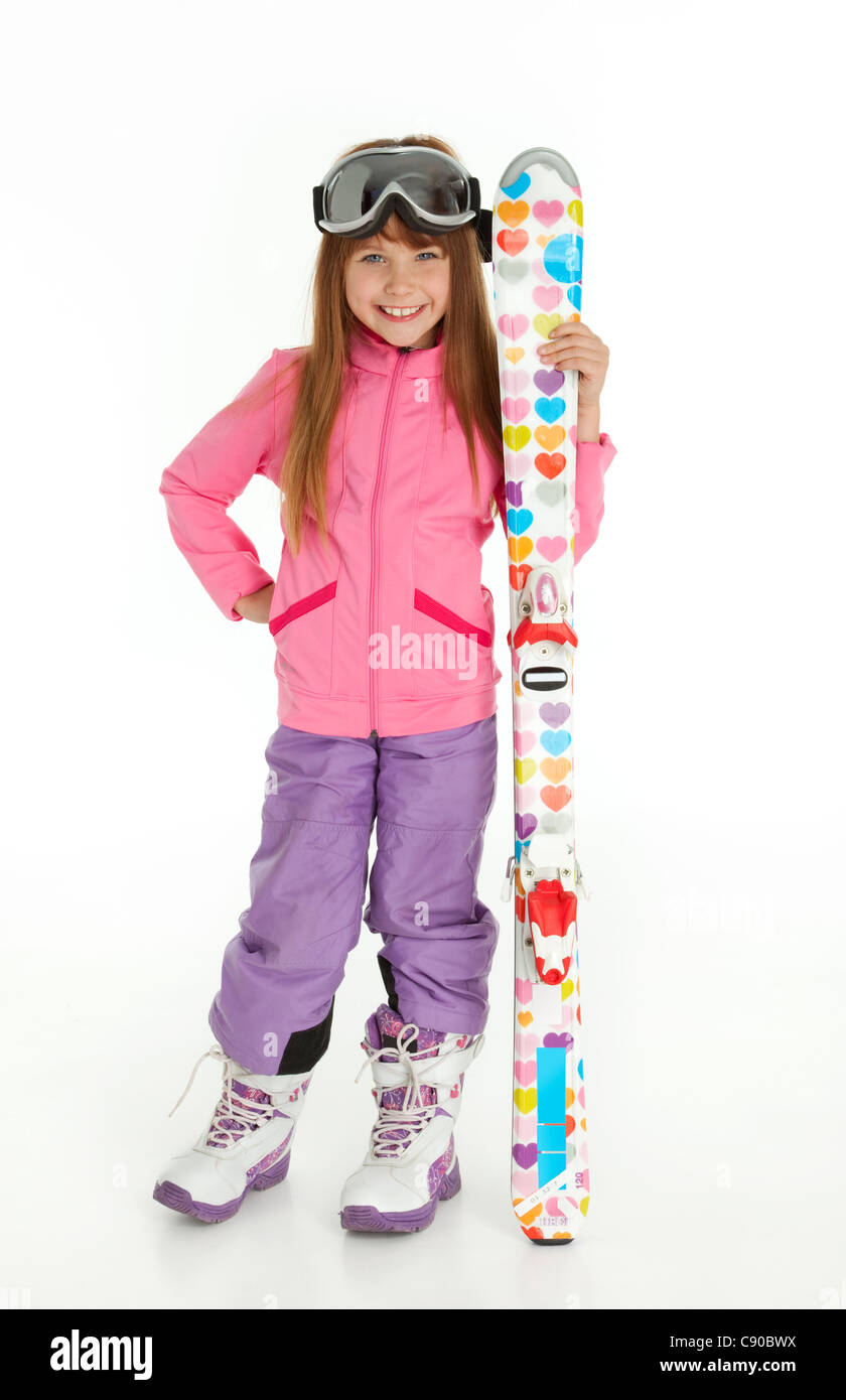 Longueur complète photo de petite fille vêtue de ski wear holding skis colorés, debout sur fond blanc. Banque D'Images