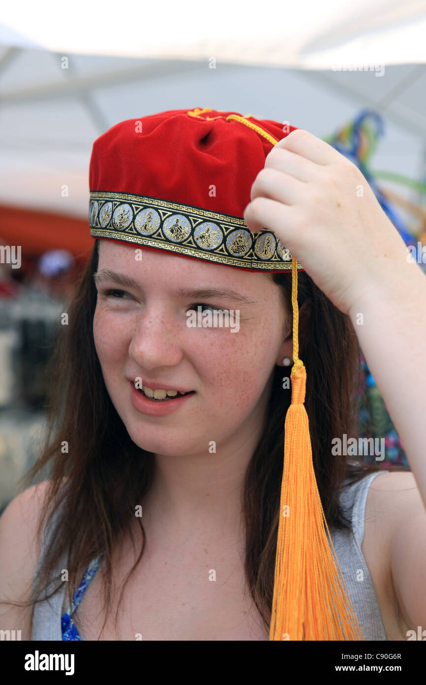 Adolescente essayant sur un chapeau traditionnel grec à un étal de  souvenirs au Canal de Corinthe en Grèce Photo Stock - Alamy