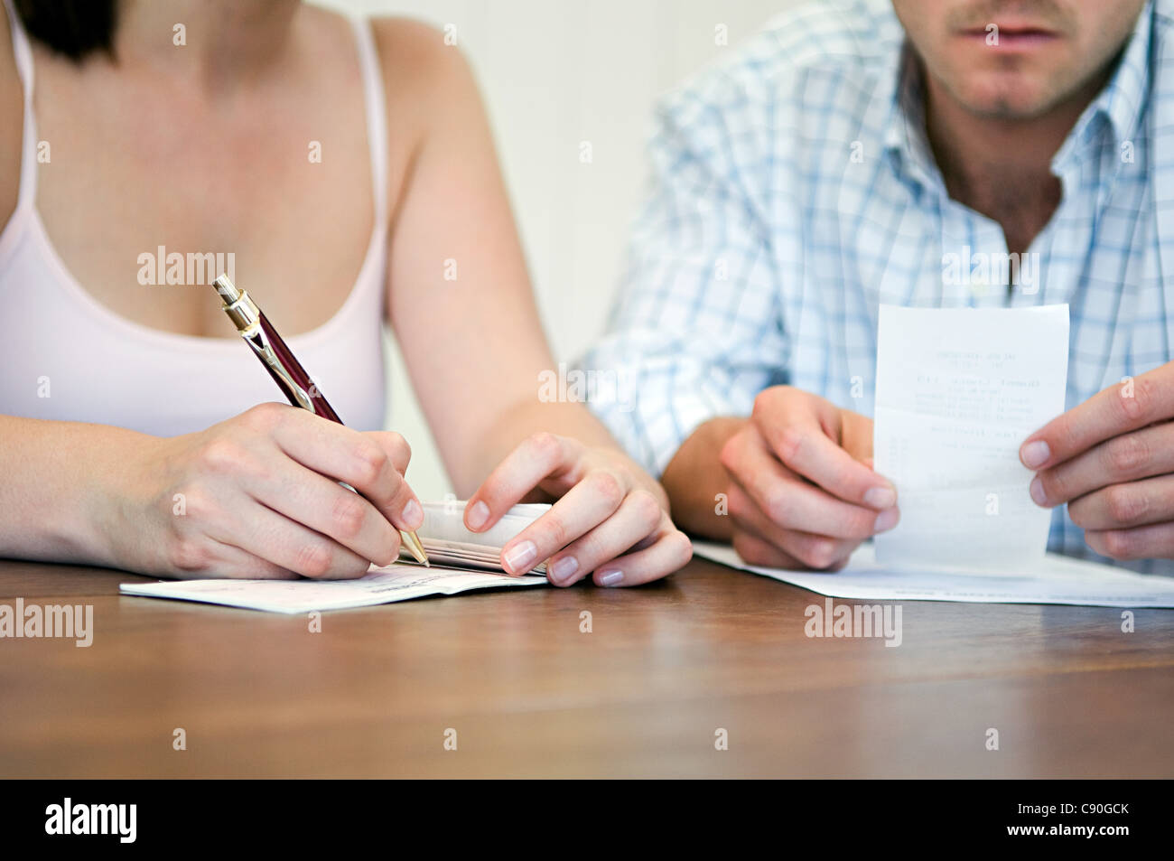 Couple planning home finances, woman writing vérifier Banque D'Images