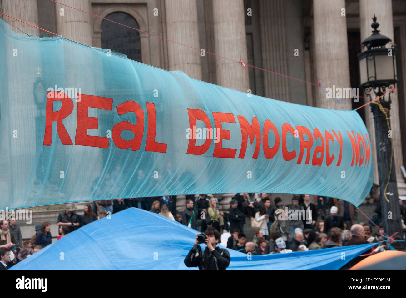 Occupy London. St Paul's. Protestation contre la ville et les banques. Dit bannière démocratie réelle maintenant Banque D'Images