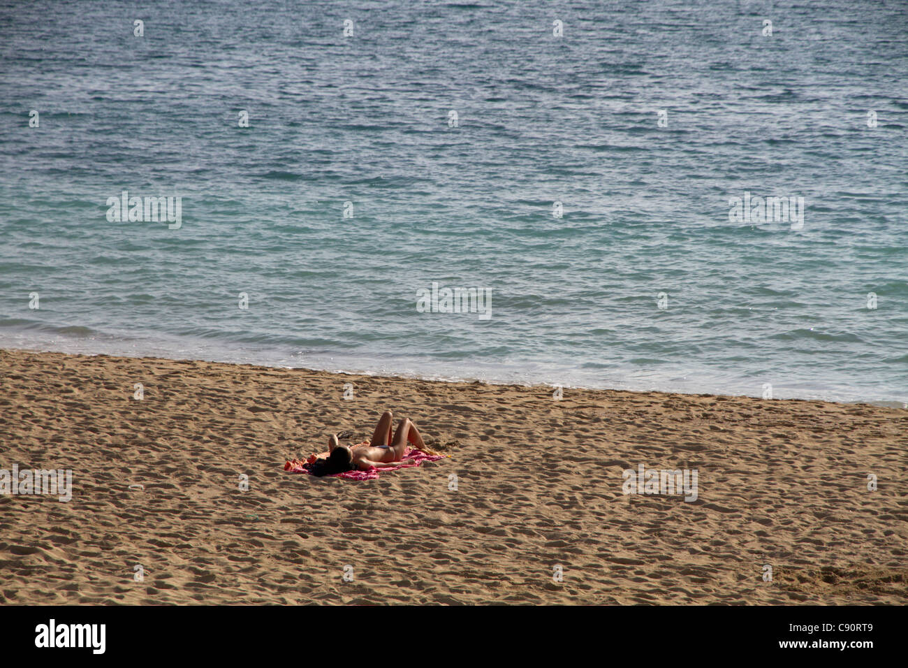 Jeune femme topless sur la plage soleil relaxant seul Mallorca Majorque Îles Baléares Espagne Banque D'Images