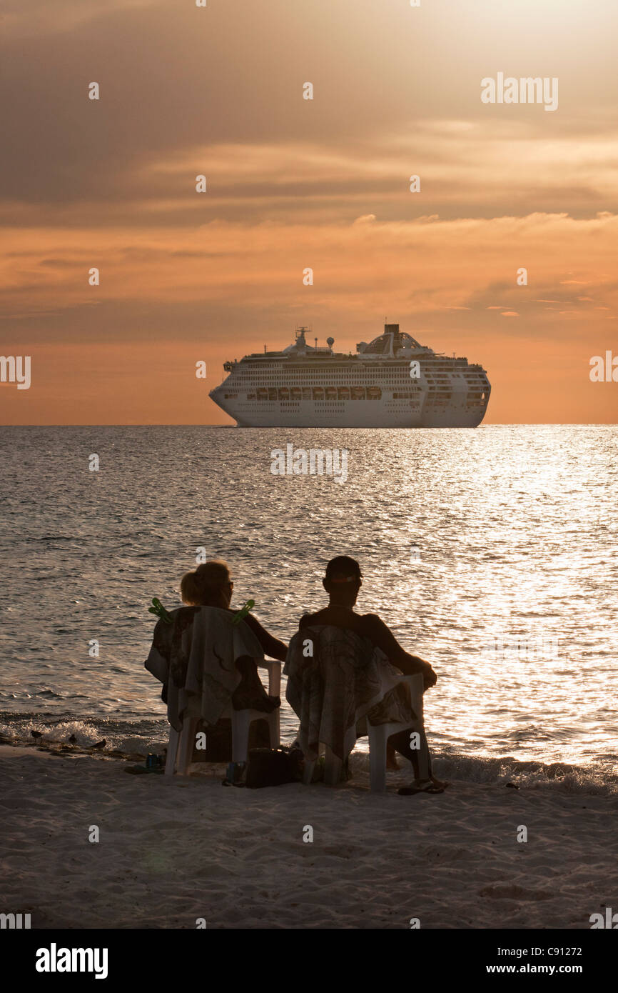 Les Pays-Bas, l'île de Bonaire, Antilles néerlandaises, Kralendijk, navire de croisière. Couple relaxing on beach. Le coucher du soleil. Banque D'Images
