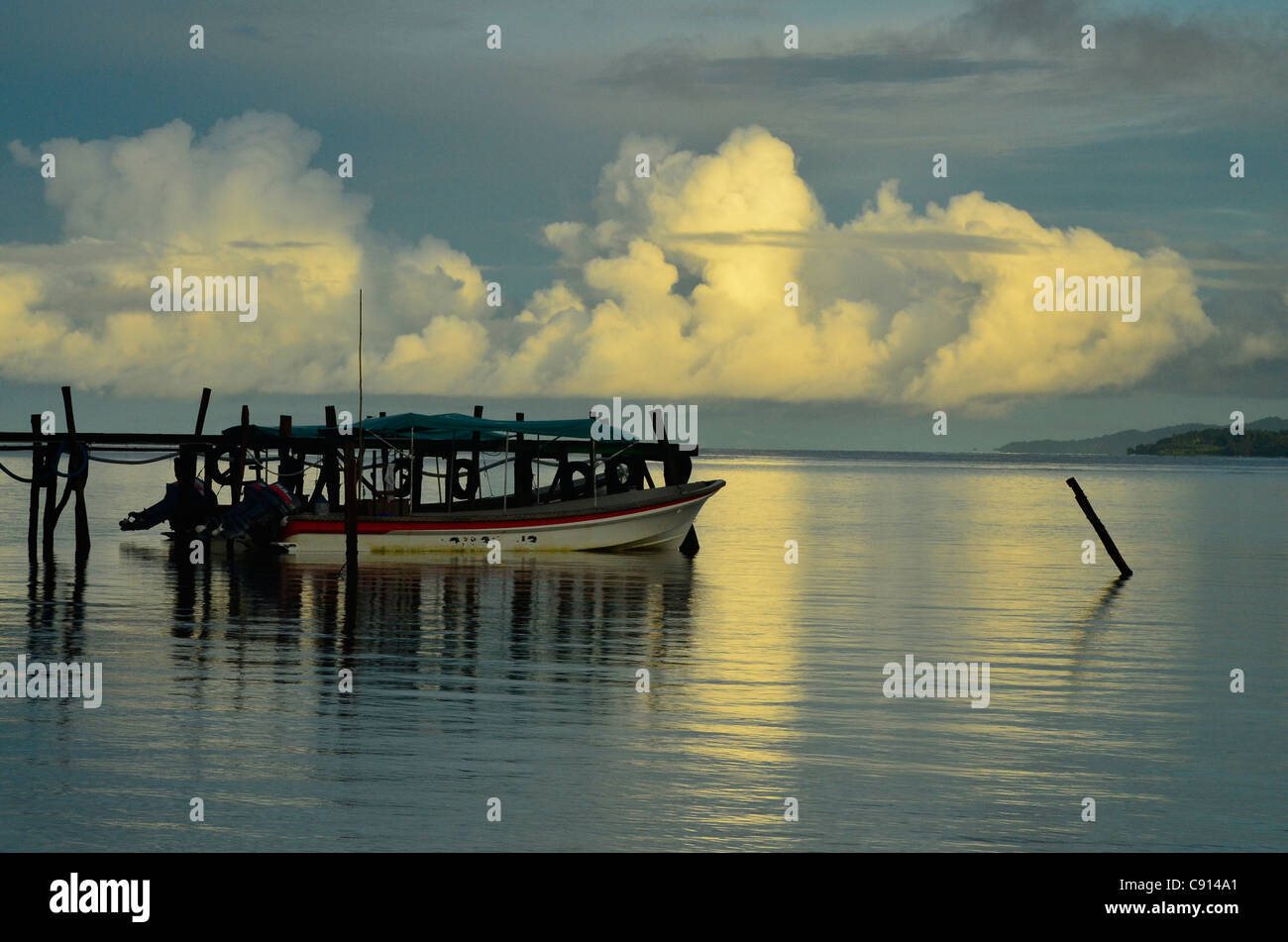 Bateau amarré à l'embarcadère de Kri Resort sur Raja Ampat islands matin orageux de Papouasie occidentale dans l'océan Pacifique, l'Indonésie. Banque D'Images