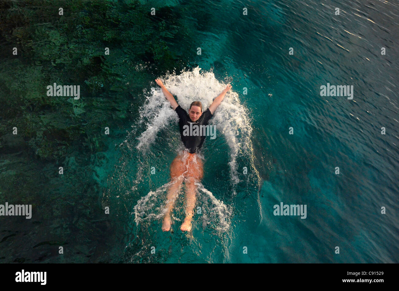 Bénéficiant d''une jetée à off dip coucher de Kri Eco Resort, Raja Ampat îles de Papouasie occidentale dans l'océan Pacifique, l'Indonésie. Banque D'Images