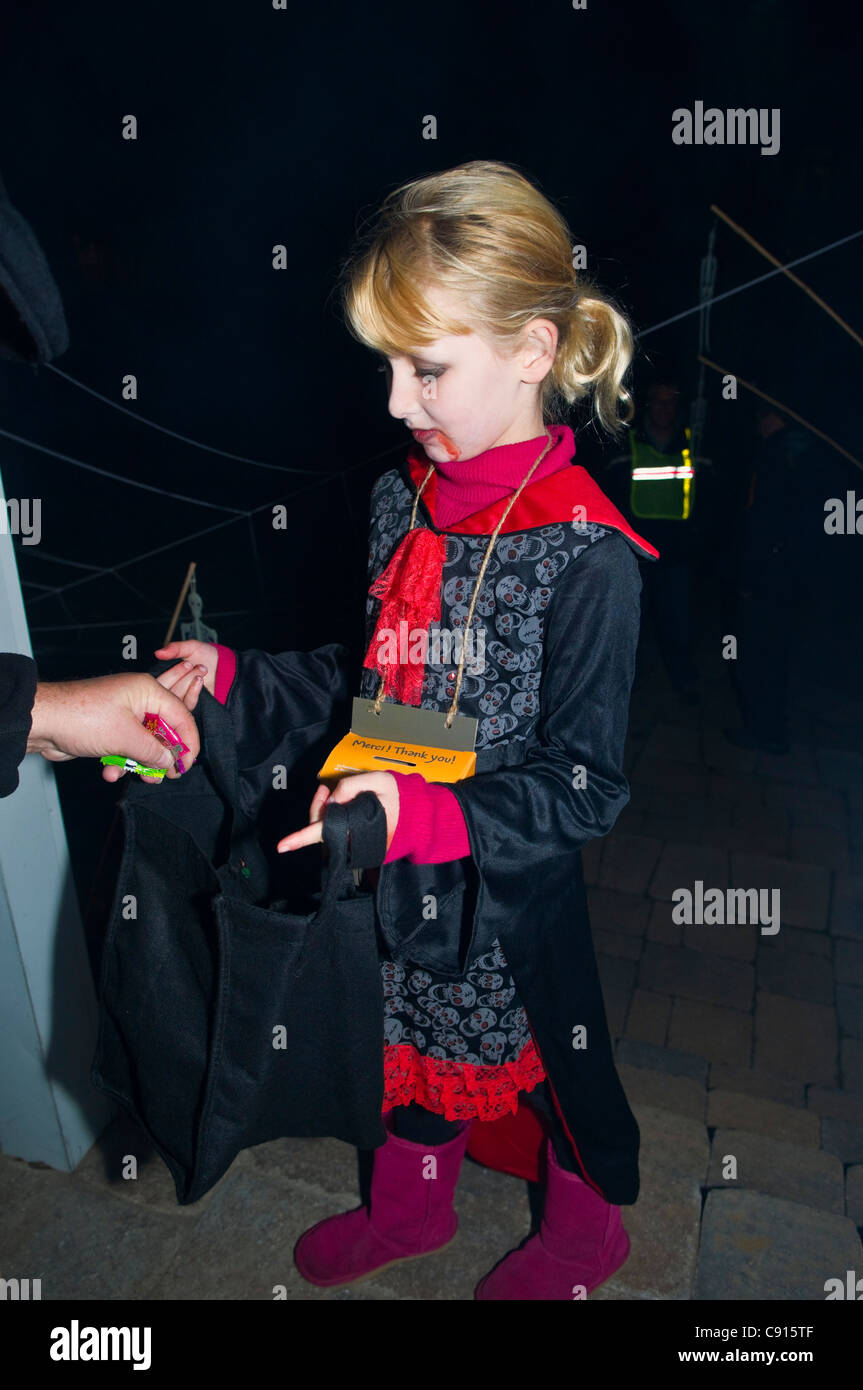 La collecte de l'enfant au cours de bonbons trick ou traiter à l'Halloween nuit Canada Banque D'Images