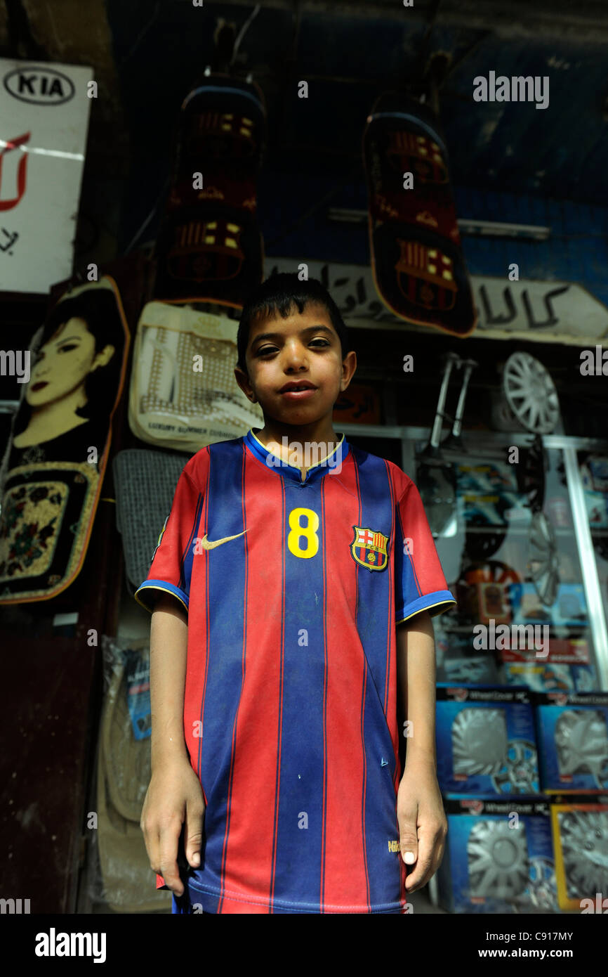 L'Iraq, jeune garçon vêtu de la chemise du FC Barcelone. Le logo est  utilisé sur les tapis de sol voiture accroché derrière le garçon Photo  Stock - Alamy