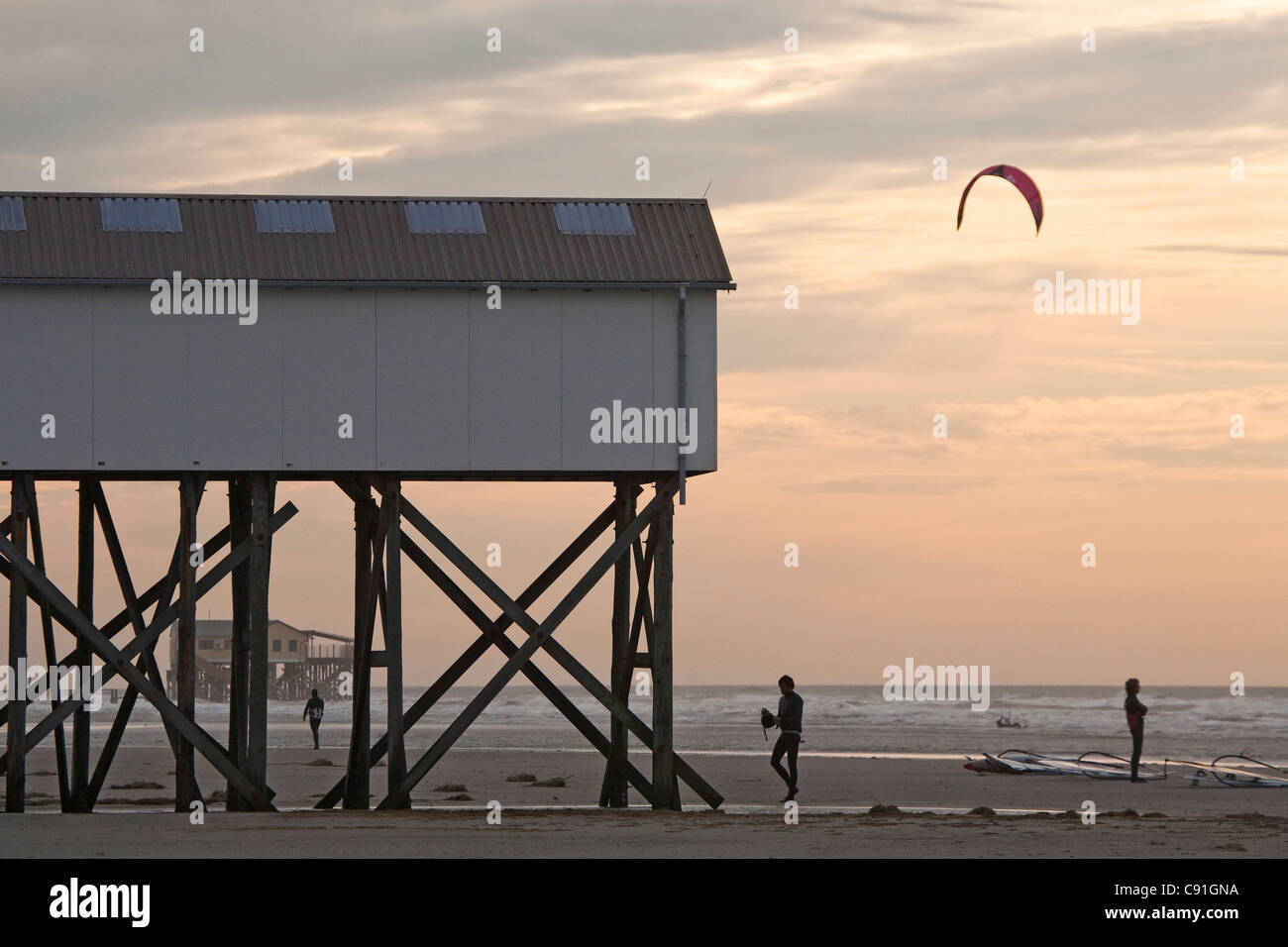 Bâtiments sur pilotis, kite surfer sur la plage de St Peter-Ording, Schleswig-Holstein, côte de la mer du Nord, Allemagne Banque D'Images