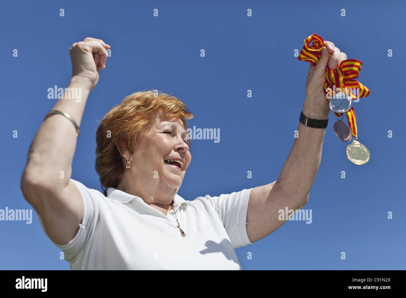 Femme plus âgée avec des médailles d'encouragement Banque D'Images