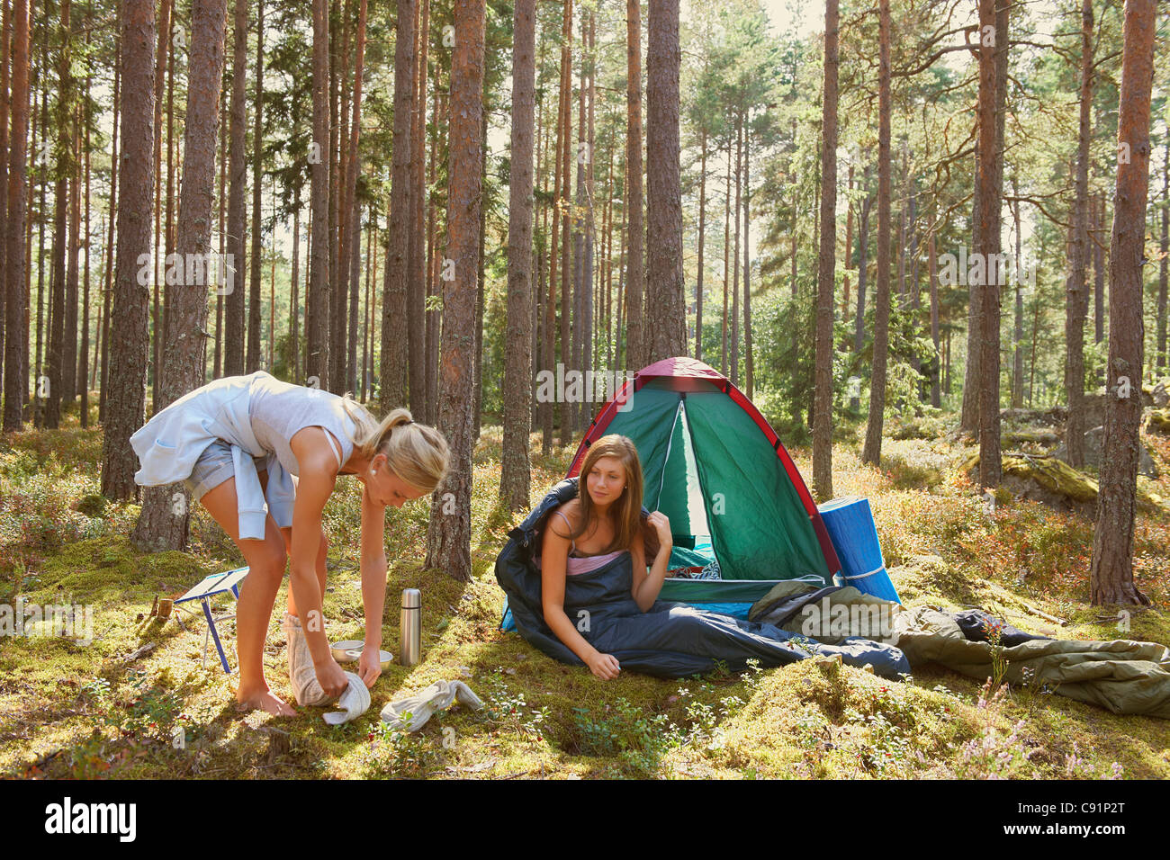 Les femmes la mise en place de camping en forêt Banque D'Images