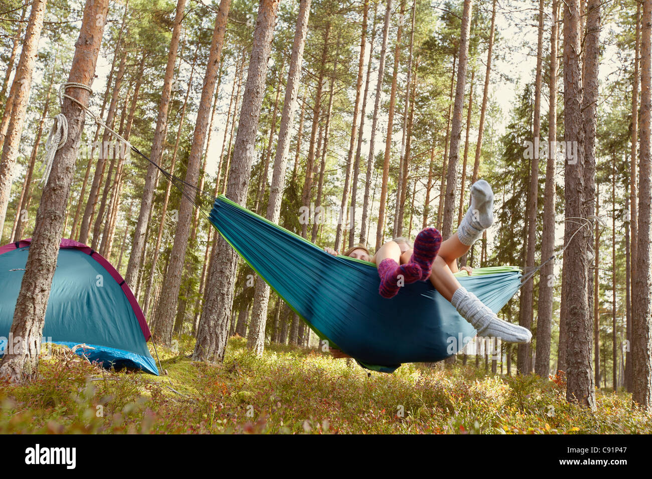 Women relaxing in hammock at campsite Banque D'Images