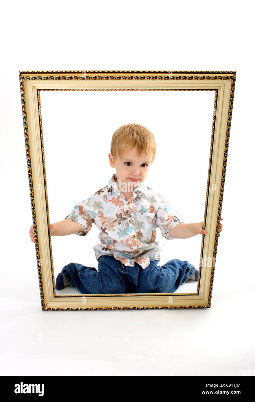 Un jeune homme enfant bébé garçon tenant une grande photo cadre à lui-même comme la photo, sur un fond blanc coupé Banque D'Images