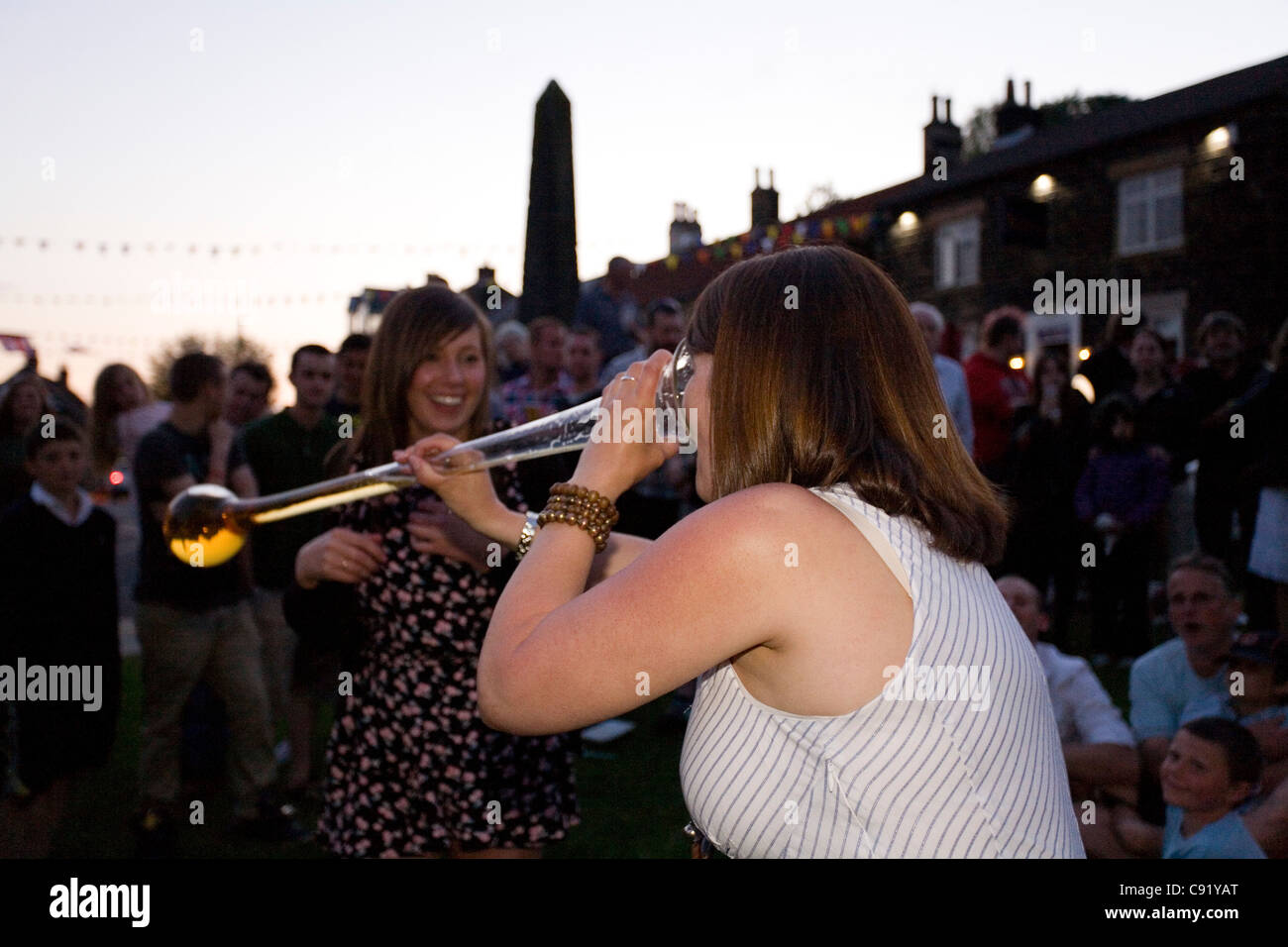 Jeune femme à boire de la bière anglaise de cour pendant les Jeux d'été Village Osmotherley North Yorkshire Angleterre Banque D'Images