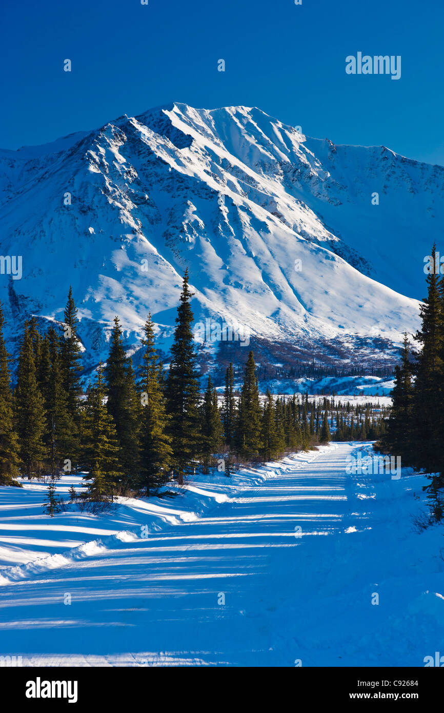 La neige a couvert route menant vers les montagnes au large col, Southcentral Alaska, Winter Banque D'Images
