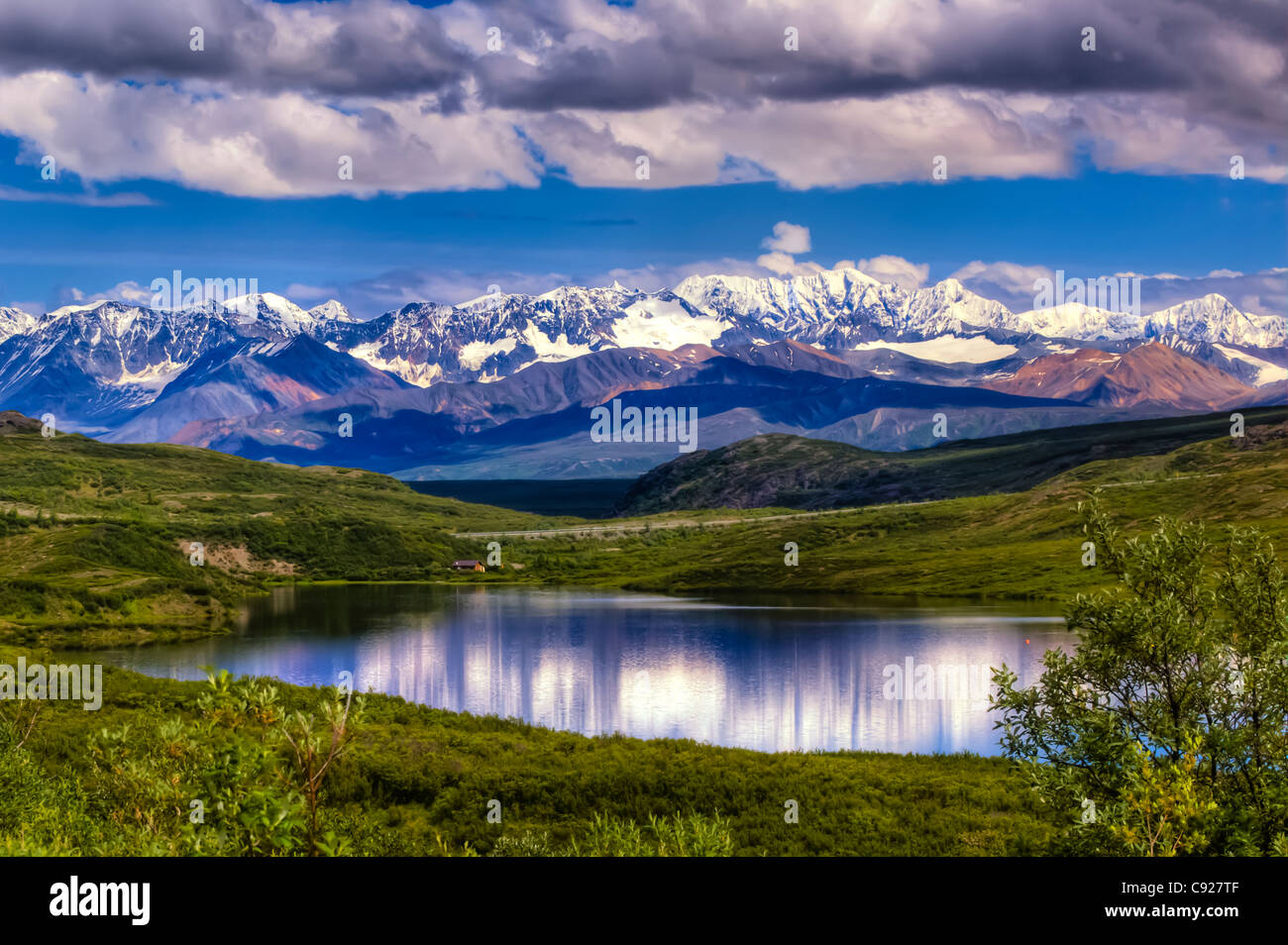 Vue panoramique sur une petite cabane sur un lac le long de la Denali Highway avec la chaîne de l'Alaska derrière, Southcenral l'Alaska, l'été, HDR Banque D'Images