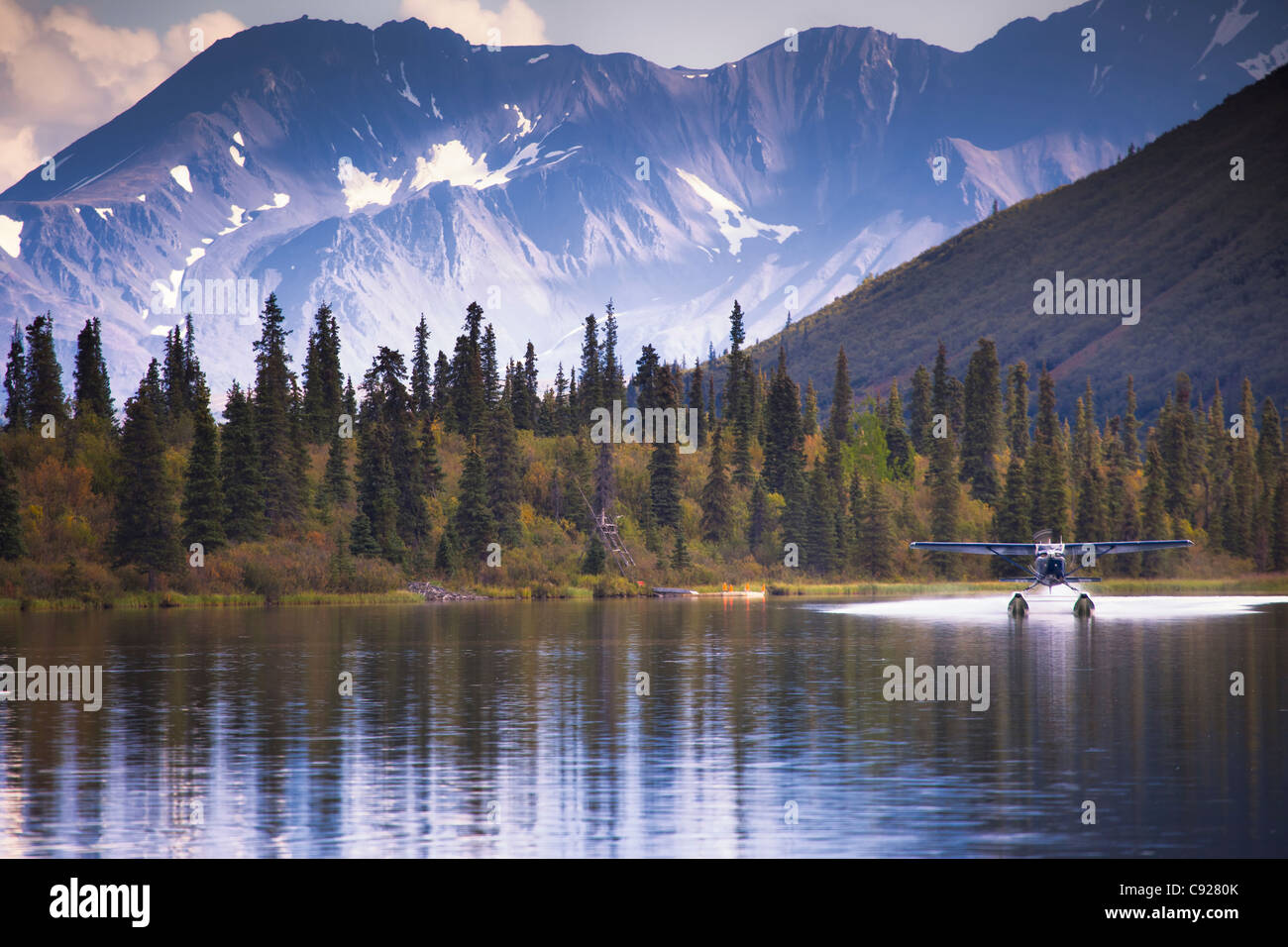 Un Cessna 206 sur flotteurs sur les terres du lac près de la puntilla Rainy Pass Lodge avec des montagnes et des couleurs de l'automne en arrière-plan, de l'Alaska Banque D'Images
