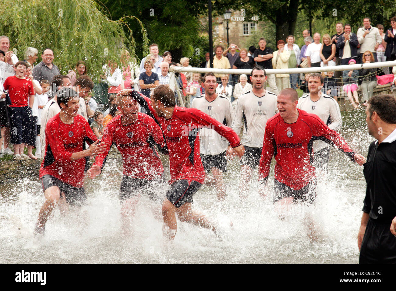 L'annuel original football dans la rivière, a lieu le lundi férié en Bourton-on-the-water, Gloucestershire, Angleterre Banque D'Images