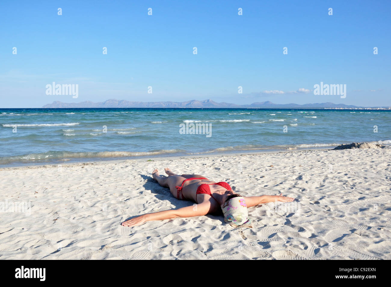 Mid adult woman sunbathing on beach, Alcudia, Mallorca, Spain, Europe Banque D'Images