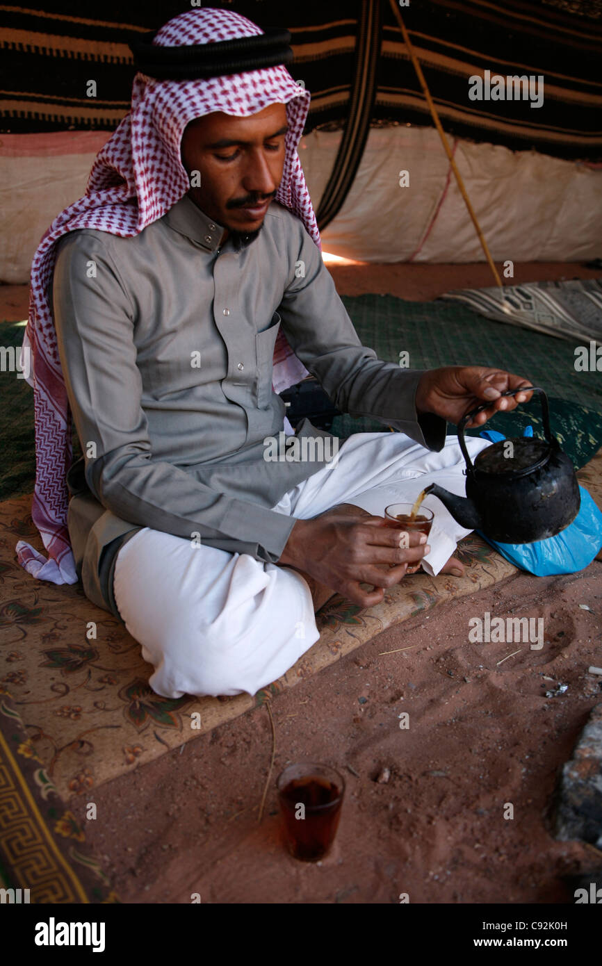 Bedouin man pouring tea à l'intérieur d'une tente, Wadi Rum, Jordanie. Banque D'Images