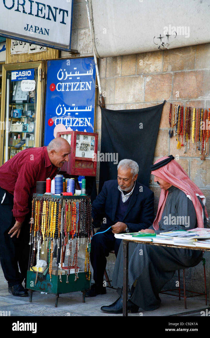 Les hommes, à un étal vendant à l'extérieur de l'perles retrouvez Al Husseiny mosquée au centre-ville d'Amman, en Jordanie. Banque D'Images