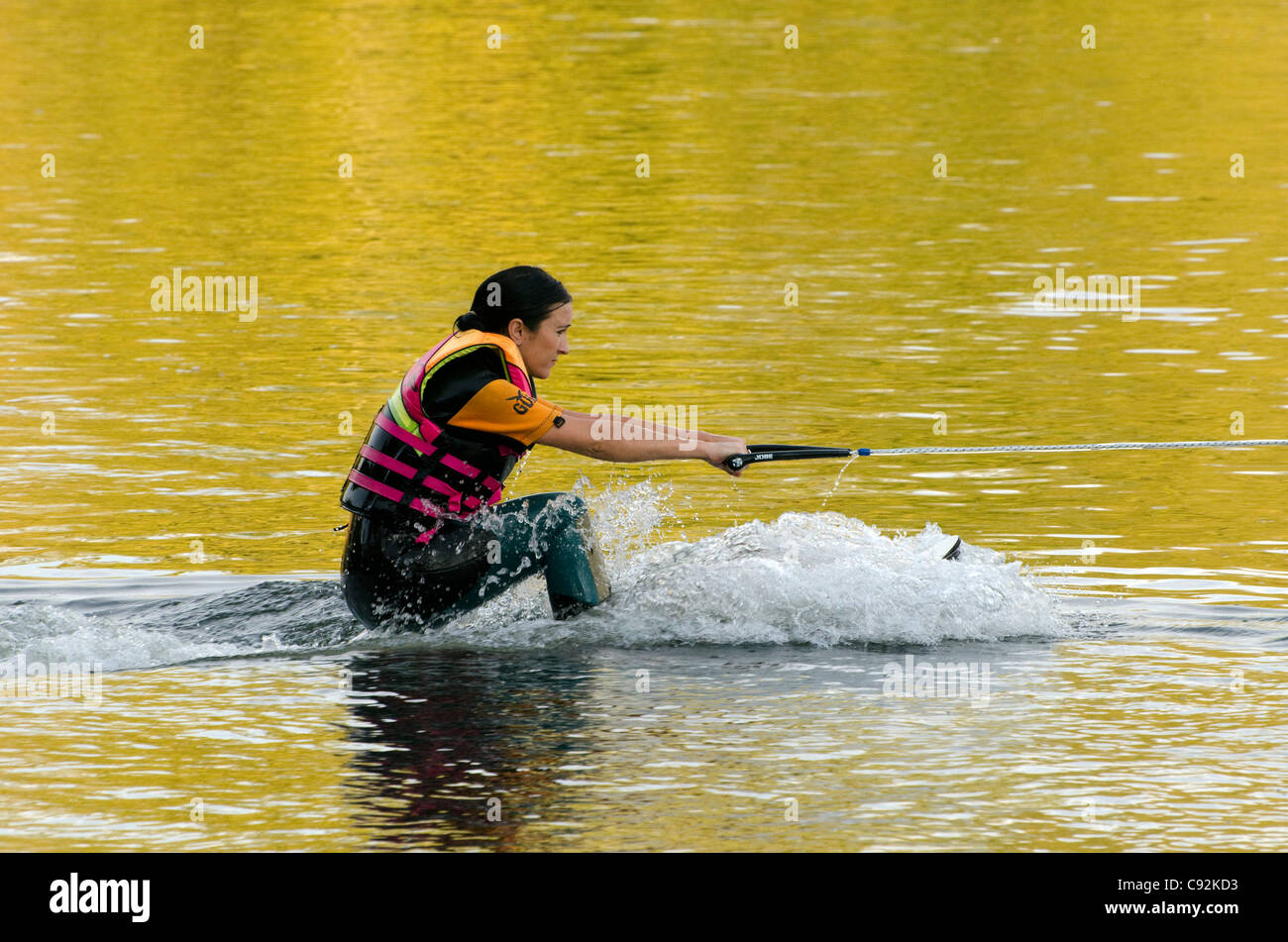 Une skieuse nautique tracté par un bateau l'accélération sur le lac Batchworth Rickmansworth Aquadrome Herts UK Banque D'Images