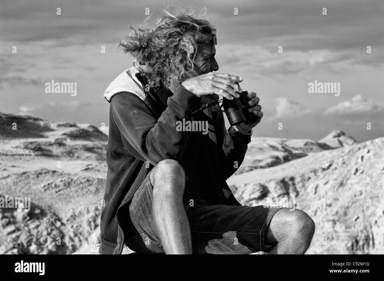 Rugged Man Holding Binoculars et à l'Écart Banque D'Images