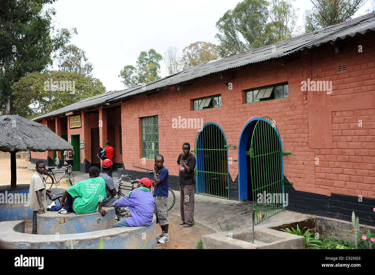 Les habitants du Zimbabwe à discuter à l'extérieur seule boutique sur Imire Safari Ranch, Harare, Zimbabwe. Banque D'Images