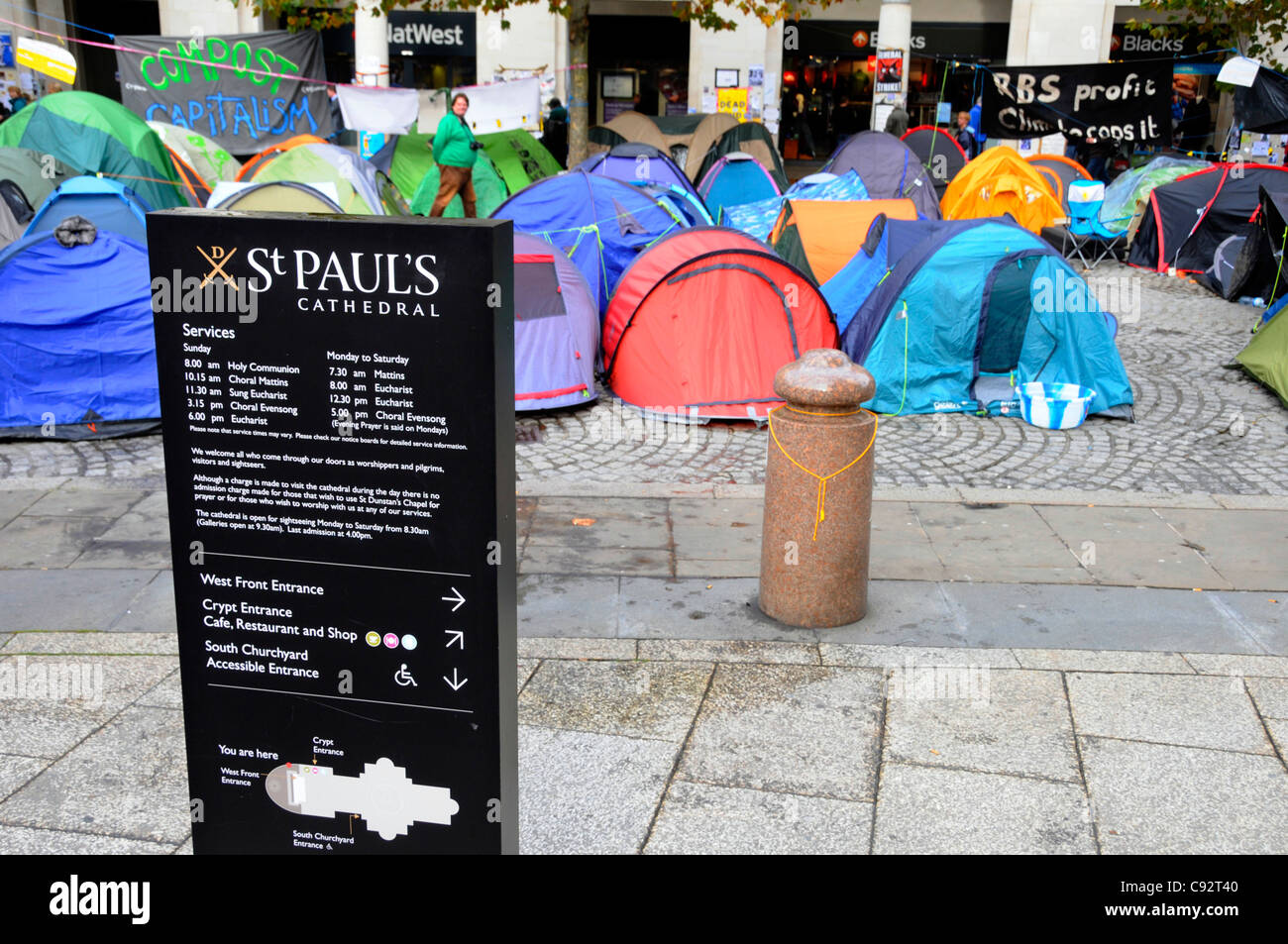Cathédrale St Paul panneau d'information avec les manifestants capitaliste de tentes et d'entrée de la Bourse au-delà Ville de London England UK Banque D'Images