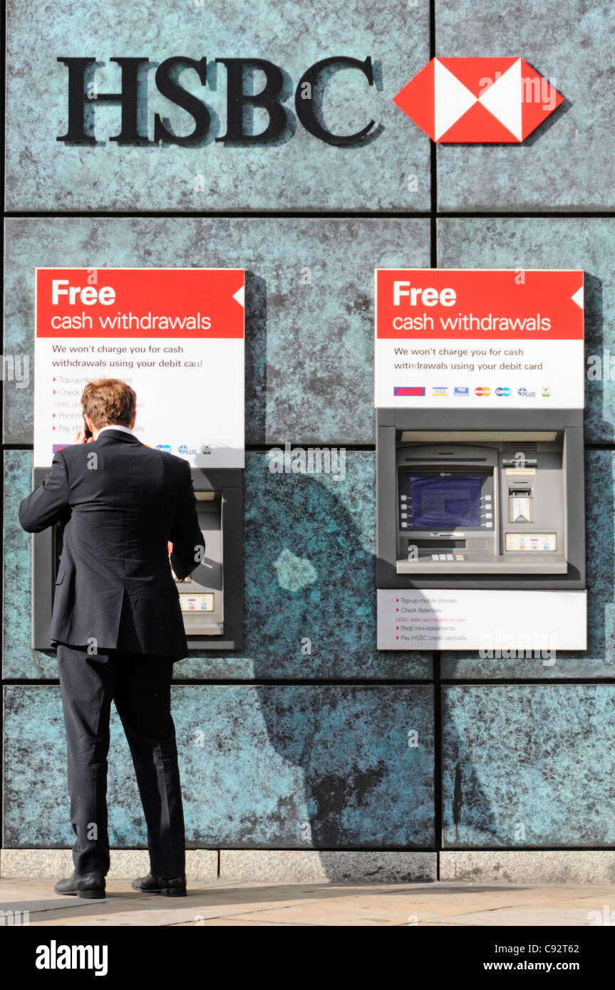 Businessman retirer de l'argent de l'un des deux guichets ATM HSBC Banque D'Images