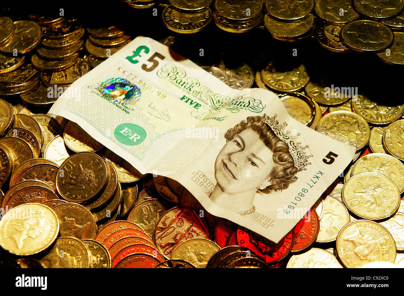 Focalisation étroite délibérée. UK de monnaie et Queen's head 5 lb bank note. Station de jeux électroniques Penny Falls machine de jeu Banque D'Images