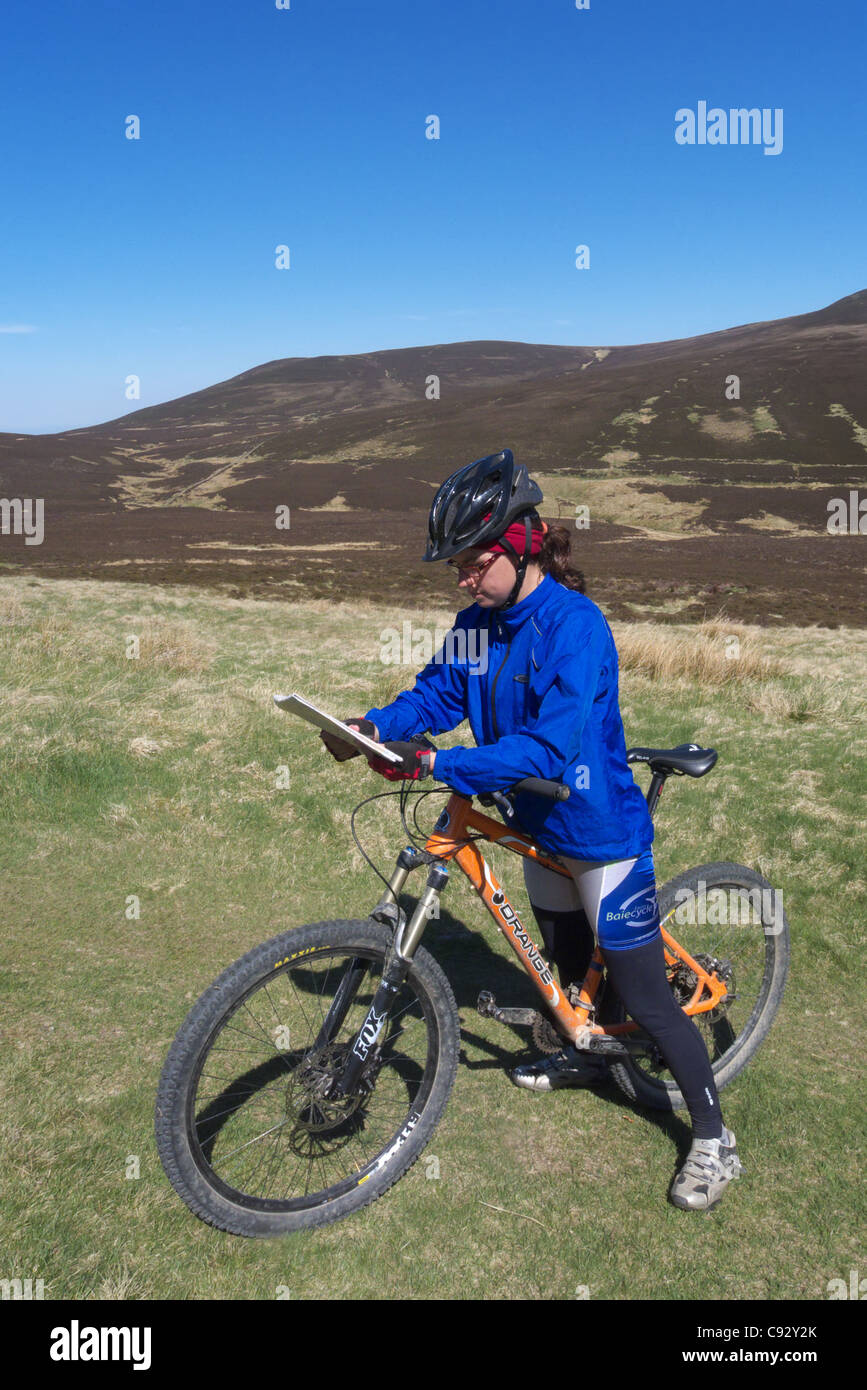 Une dame du vélo de montagne en regardant une carte Banque D'Images