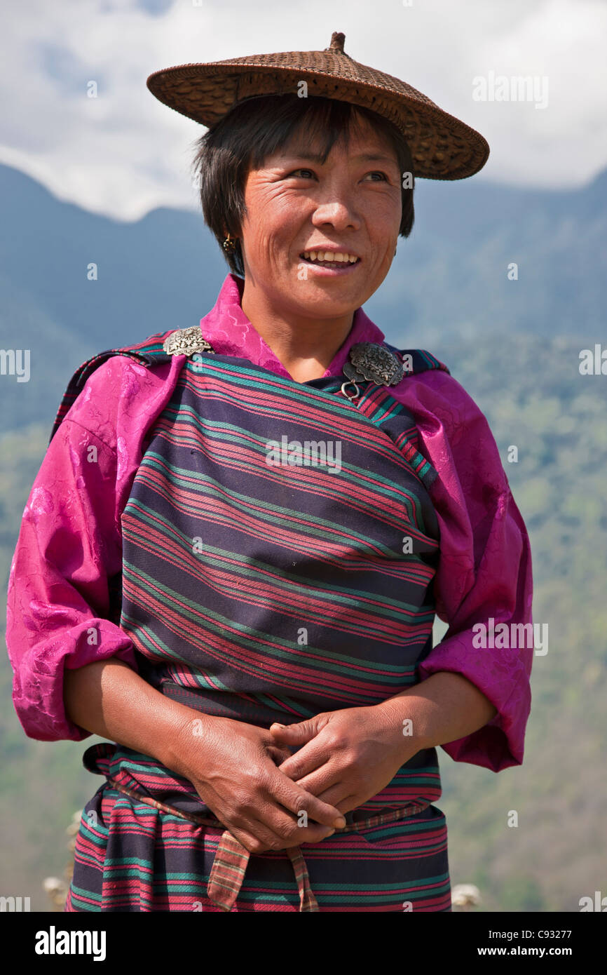 Une femme habillés en costume national à son hillside farm dans la vallée Mangde Chhu. Banque D'Images