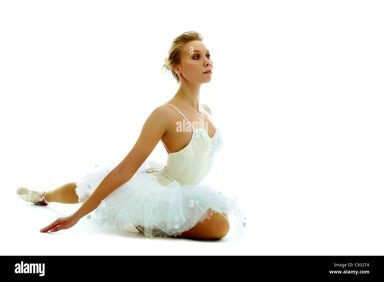 Portrait de ballerine gracieuse assis avec le bras tendu sur fond blanc Banque D'Images