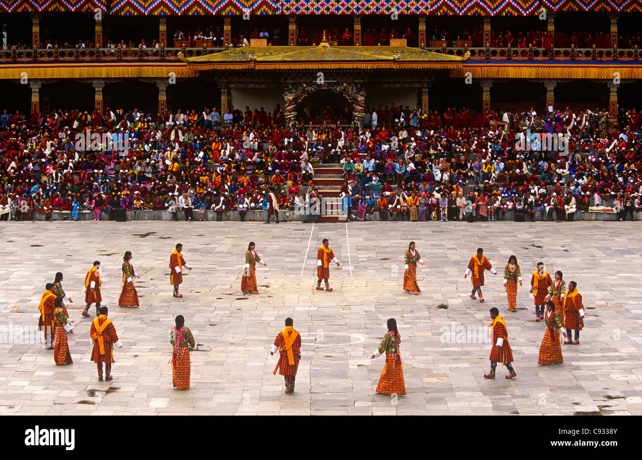 Le Bhoutan, Thimphu. Danseurs portant des Bhoutanais traditionnel effectuer robe dans une cour à côté Trashi Chhoe Dzong. Banque D'Images