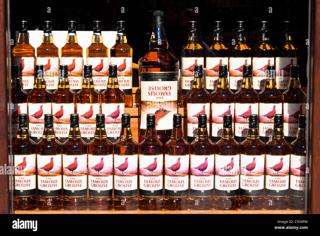 Détail de l'affiche de vitrine avec des bouteilles de scotch whisky, The Famous Grouse. Banque D'Images