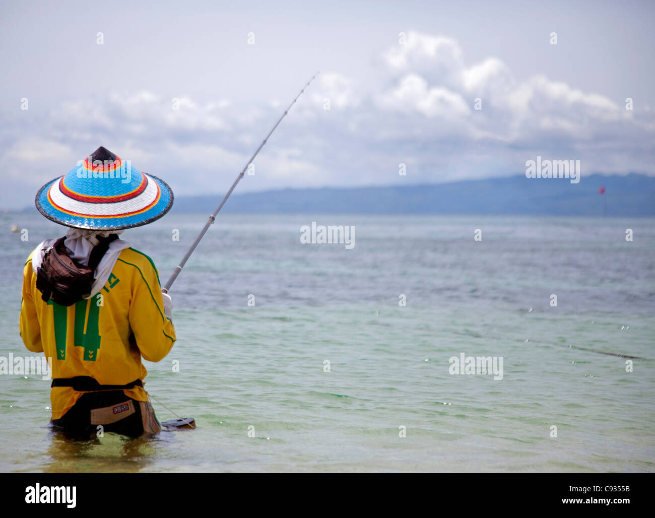 Bali, Padang Bai. Un pêcheur local bien protégé du soleil de midi féroce. Banque D'Images