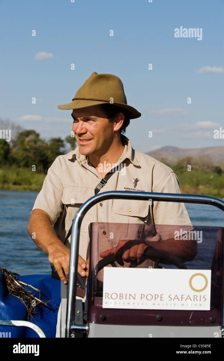 Au Malawi, la Réserve de faune majete. Un guide avec Robin Pope Safaris conduit un bateau vue de jeu le long de la Rivière Shire. Banque D'Images