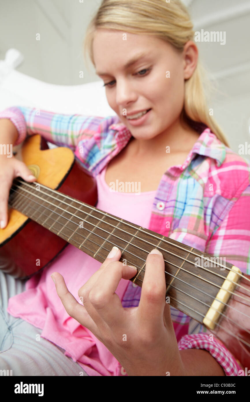 Teenage girl playing acoustic guitar Banque D'Images