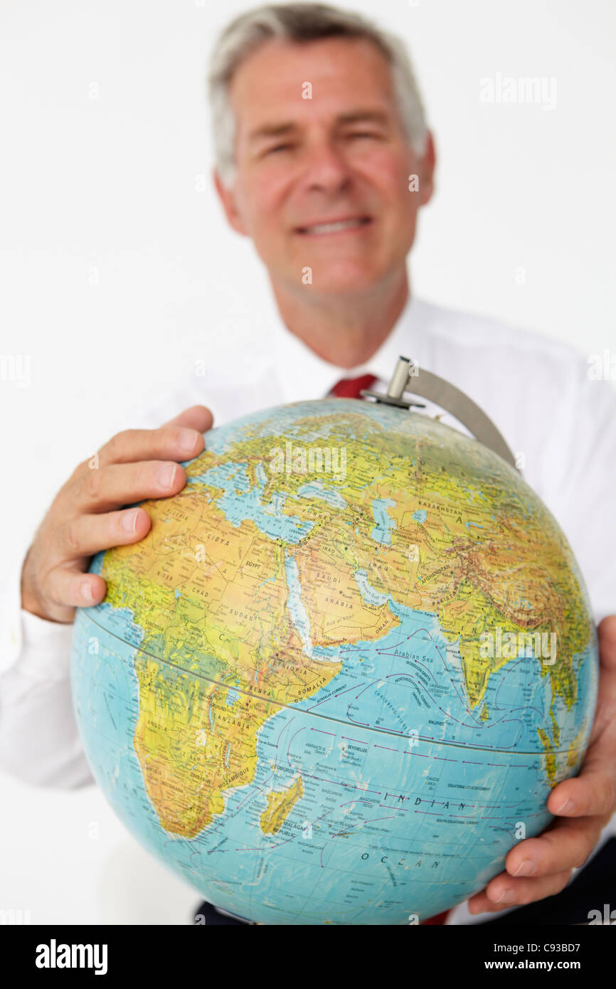 Senior businessman holding globe Banque D'Images