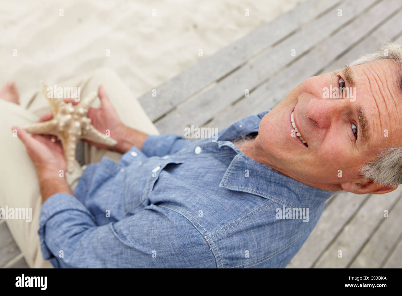 Senior man holding starfish Banque D'Images